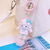 Velvet Whispers: Hand-Painted Chibi Charm with Fluffy Pom-Pom Accents